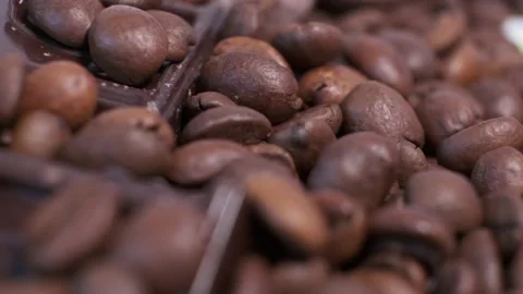 Close-up of dark roasted coffee beans and chocolate on rotating table. Stock Footage 140675982