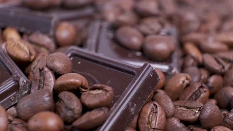 Close-up of dark roasted coffee beans and chocolate on rotating table. Stock Footage 140972194