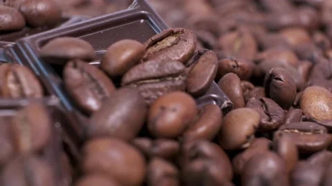 Close-up of dark roasted coffee beans and chocolate on rotating table. Stock Footage 141053273