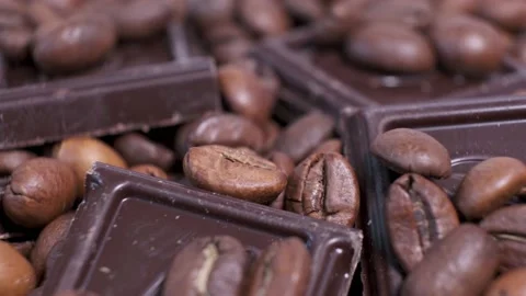 Close-up of dark roasted coffee beans and chocolate on rotating table. Stock Footage 141331878