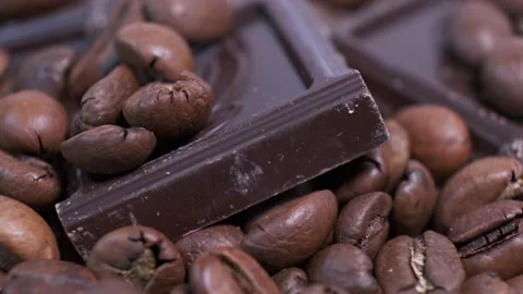 Close-up of dark roasted coffee beans and chocolate on rotating table. Stock Footage 141381442