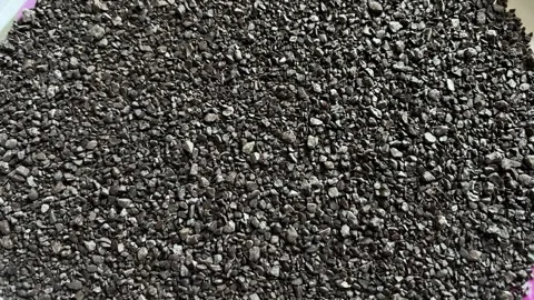 Close-up of dark roasted ground coffee powder or granules spread on a plate Видео 328633503