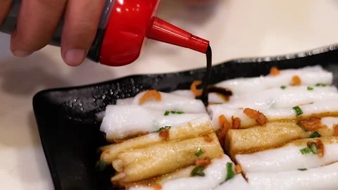 Close Up of Dark Sauce Being Poured Over Rice Noodle Rolls Vídeo Stock 329265104