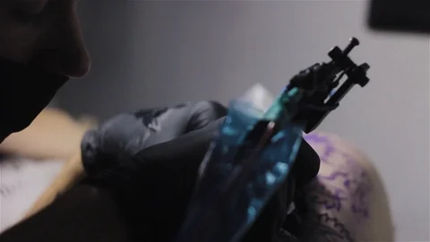 Close up dark slide shoot of tattoo artist making old school tattoo Stock Footage 93144852