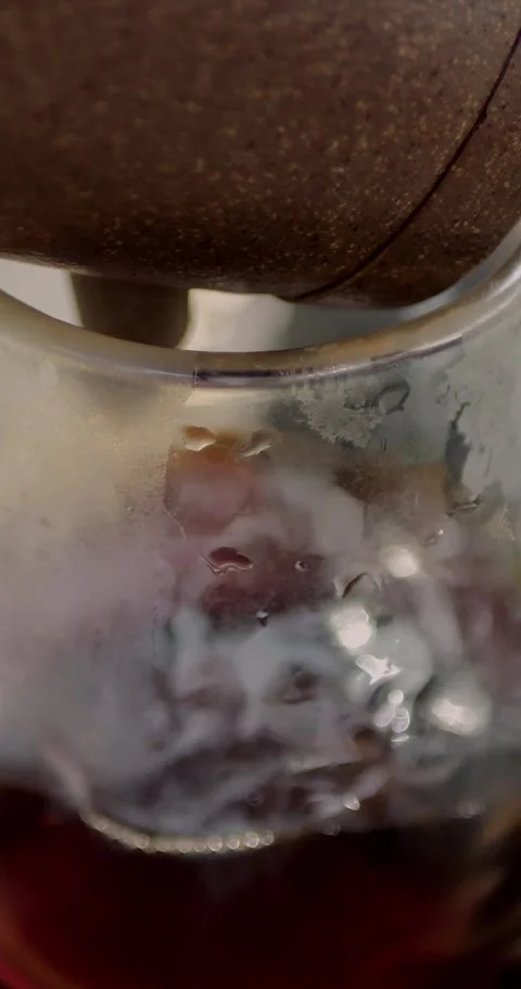 Close-up of dark tea being poured from a clay teapot into a clear... Stock Footage 344454744