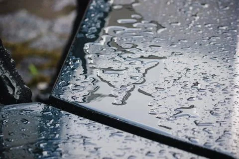 Close up of a dark, wet table surface covered in water puddles and rain wit.. Stock Photos