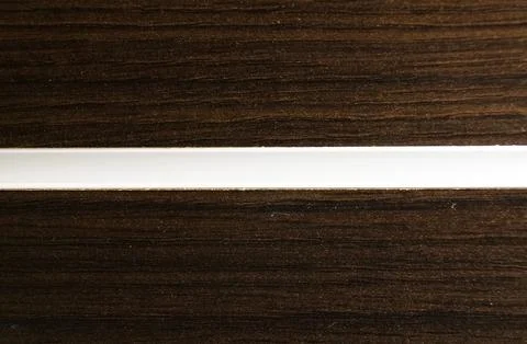 Close-up of dark wood grain texture bisected by a clean, horizontal white inl Stock Photos