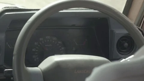 CLOSE UP: Dashboard and speedometer in old safari jeep speeding on dusty road Stock Footage 71067909