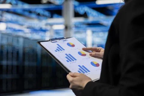 Close up of data center admin auditing documentation, checking equipment Foto stock