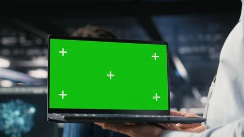 Close up of data center employee doing maintenance tasks on green screen laptop 스톡 사진