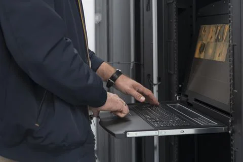 Close up on Data Center Engineer hands Using keyboard on a supercomputer Server Stock Photos