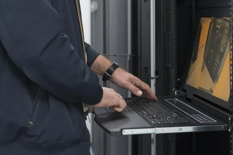 Close up on Data Center Engineer hands Using keyboard on a supercomputer Server Stock Photos