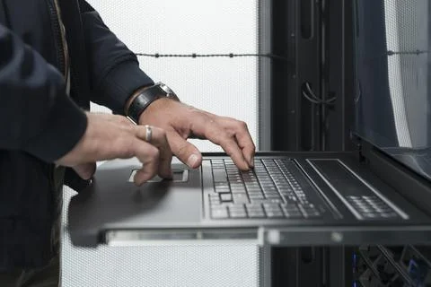 Close up on Data Center Engineer hands Using keyboard on a supercomputer Server Stock Photos