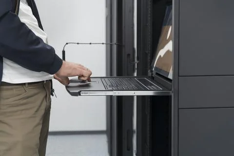 Close up on Data Center Engineer hands Using keyboard on a supercomputer Server Stock Photos