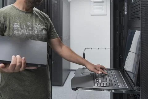 Close up on Data Center Engineer hands Using keyboard on a supercomputer Server Stock Photos