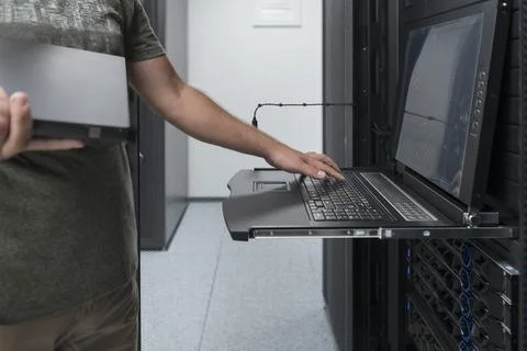 Close up on Data Center Engineer hands Using keyboard on a supercomputer Server Stock Photos