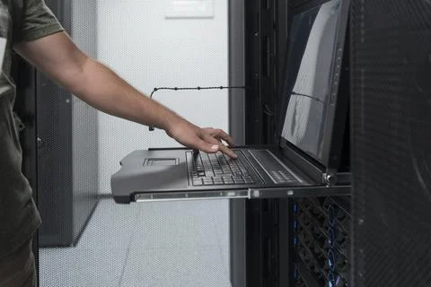Close up on Data Center Engineer hands Using keyboard on a supercomputer Server Stock Photos