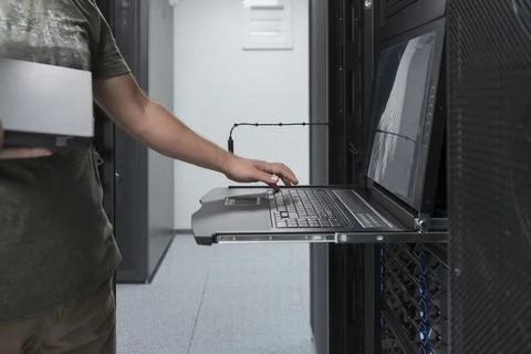 Close up on Data Center Engineer hands Using keyboard on a supercomputer Server Stock Photos