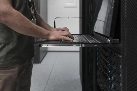 Close up on Data Center Engineer hands Using keyboard on a supercomputer Server Stock Photos