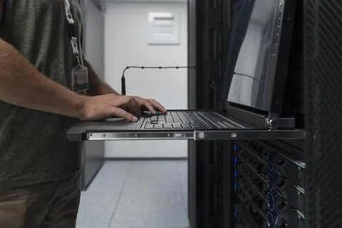 Close up on Data Center Engineer hands Using keyboard on a supercomputer Server Stock Photos