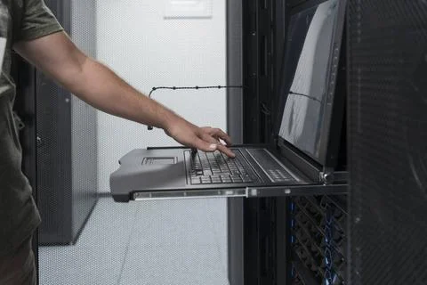 Close up on Data Center Engineer hands Using keyboard on a supercomputer S... Stock Photos