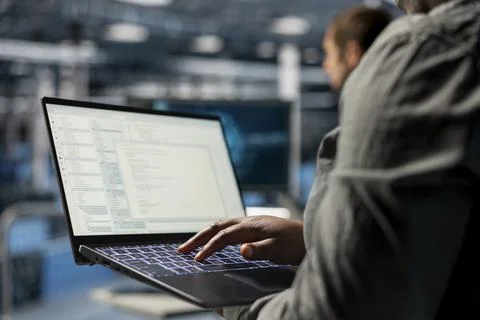 Close up of data center programmer looking at code on laptop Stock Photos