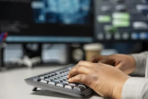 Close up of data center programmer typing on PC keyboard, using AI Stock Photos