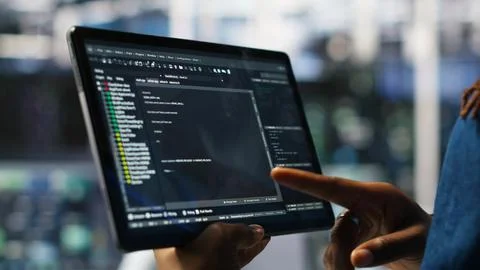 Close up of data center software developer checking code on tablet Foto stock