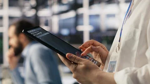 Close up of data center system administrator coding on tablet 写真素材