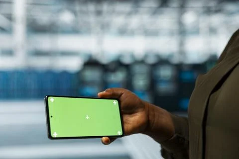 Close up of data center technician checking rigs data on chroma key smartphone Stock Photos