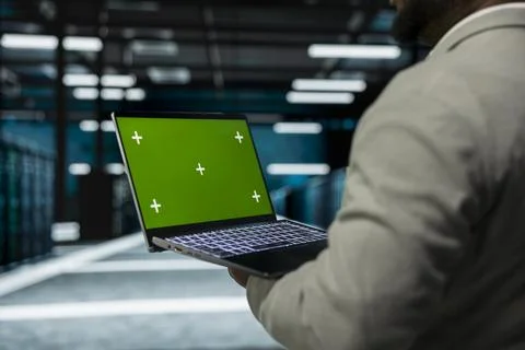 Close up of data center technician using green screen laptop, managing rigs Stock Photos