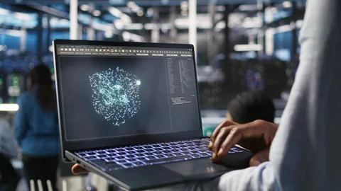 Close up of data center worker using laptop to interpret AI data analytics Stock Photos