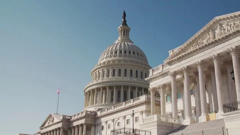 Close up of DC Capitol Building with American Flag, clear blue skies, 4K Vídeos de archivo 71378599