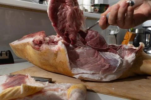 Close-Up Deboning of Bone-In Pork Leg in a Home Kitchen: Raw Meat Texture a.. Stock Photos