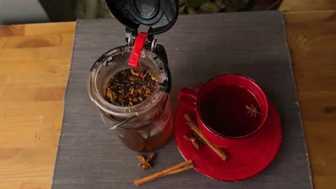 Close-up of a decanter with brewed tea and cinnamon sticks near the cup. A cup Stock Footage 149980376