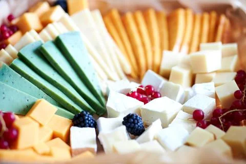 A close up of a decorated cake on a plate different cheeses Stock Photos