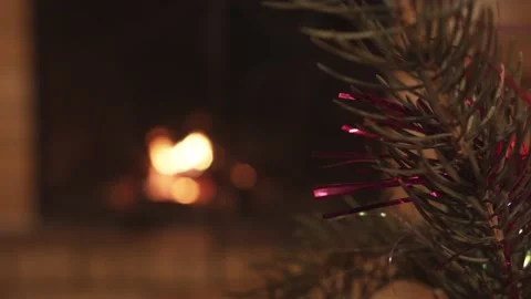 Close up Decorated x-mas tree branch against the background of fire in fireplace Stock Footage 144046920