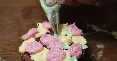 Close up of decorating a chocolate cupcake with green frosting Vídeos de archivo 117015463