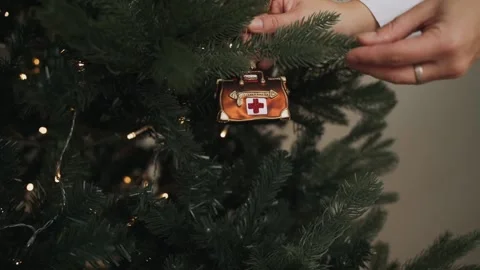 Close-up of decorating Christmas tree with doctor's bag. Stop coronavirus Stock Footage 166544587