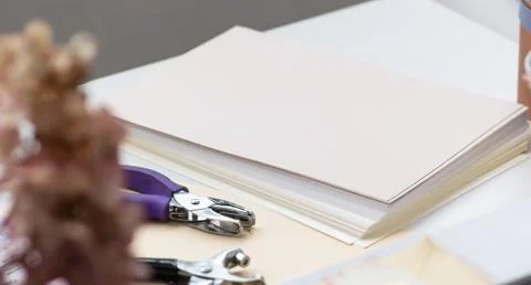 Close-up. Decorating tool and stack of sheets for making envelopes Foto stock