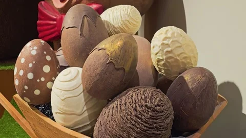Close up of decorative chocolate Easter eggs in a wooden cart, with textured Stock Footage 335220083