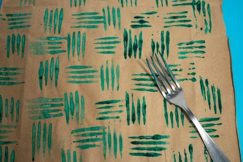 Close up of decorative stamps with fork in the paint and sheets of paper. C.. Stock Photos