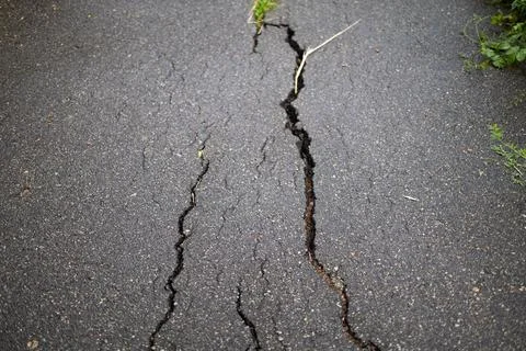 Close up of deep crack on asphalt road texture background. 写真素材