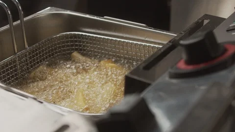 Close-up of deep-fried and boiling oil take out cooked french fries Video stock 123786133