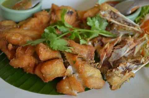 Close-up of a deep fried whole white seabass with sauce Foto stock