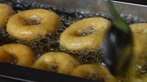 Close up deep frying ring donuts in oil Stockbeeldmateriaal 83247479