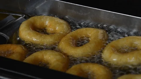 Close up deep frying ring donuts in oil Stockbeeldmateriaal 90513173
