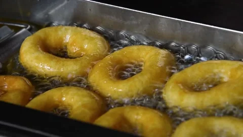 Close up deep frying ring donuts in oil Stockbeeldmateriaal 154005692