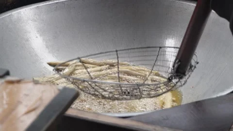 Close up of deep frying traditional snacks or dough sticks in bubbling hot cooki Video stock 337871933