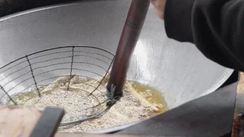 Close up of deep frying traditional snacks or dough sticks in bubbling hot cooki Stock Footage 337871943